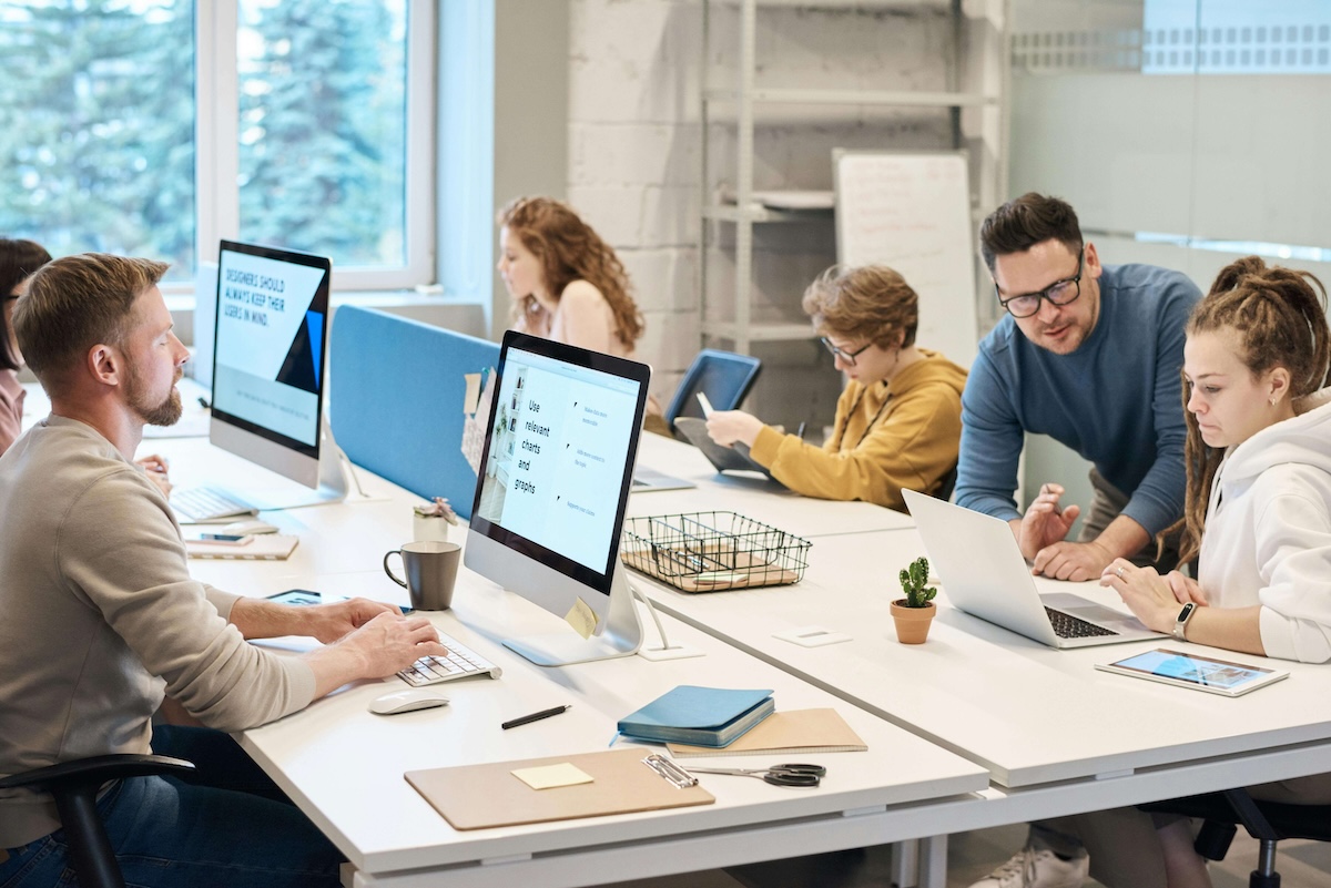 Equipe en open space lumineux travaillant sur ordinateurs